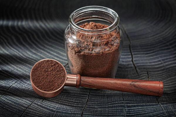 Coffee ground in glass jar and spoon with wooden handle