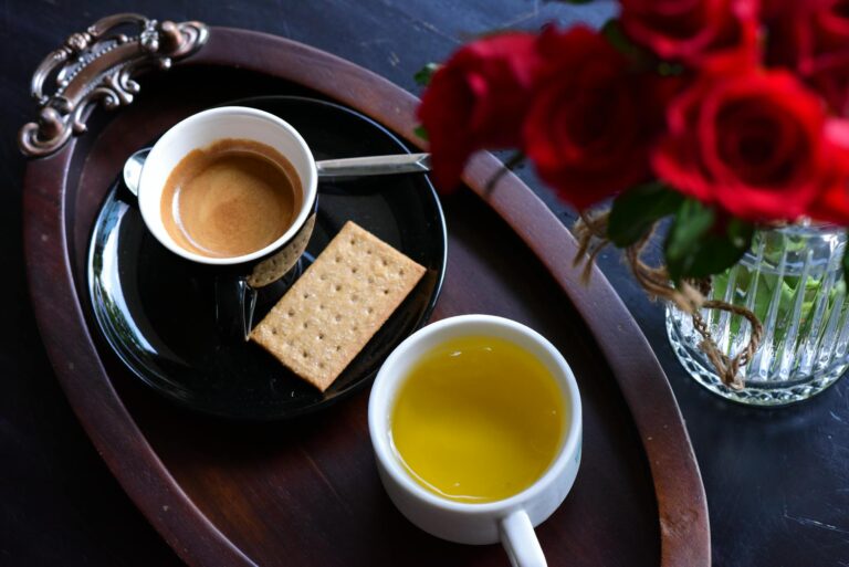 Top view of a coffee and tea setup with biscuits and roses, ideal for a cozy afternoon setting.